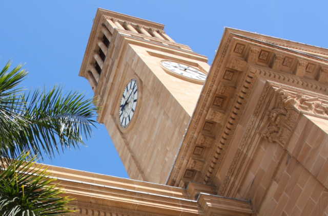 A photo of the Brisbane City Hall tower and clock, seen from below 